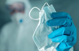 Epidemiologist offering protective respiratory mask in coronavir