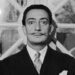 Portrait of Spanish surrealist artist Salvador Dali (1904  - 1989). He is wearing a pinstriped suit and his trademark mustache.   (Photo by Hulton Archive/Getty Images)